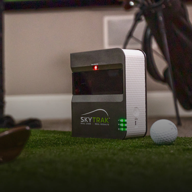 SKYTRAK golf sim indoors on mat with net accessories