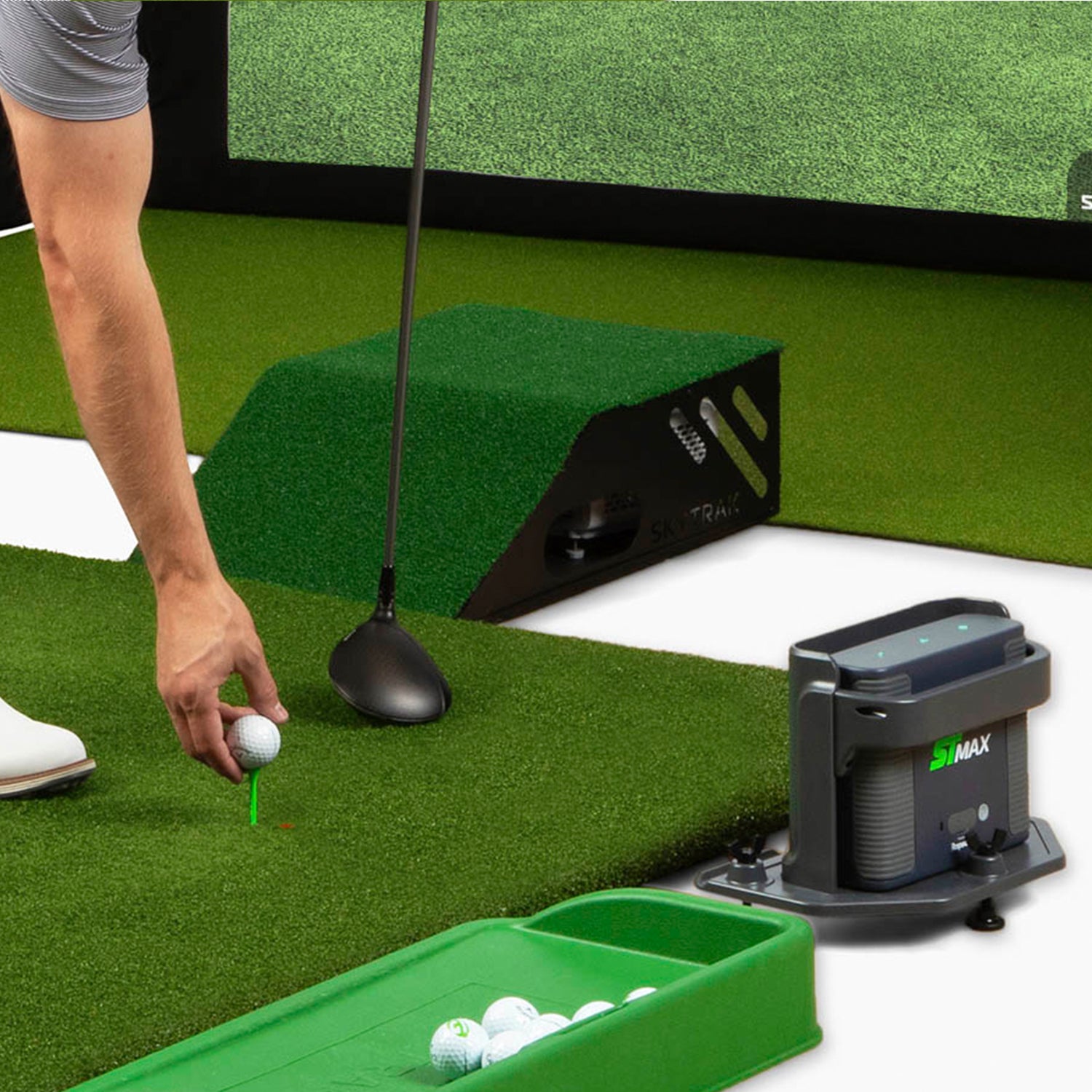 ST MAX golf launch monitor setup in home golf simulator with screen and green hitting mat.