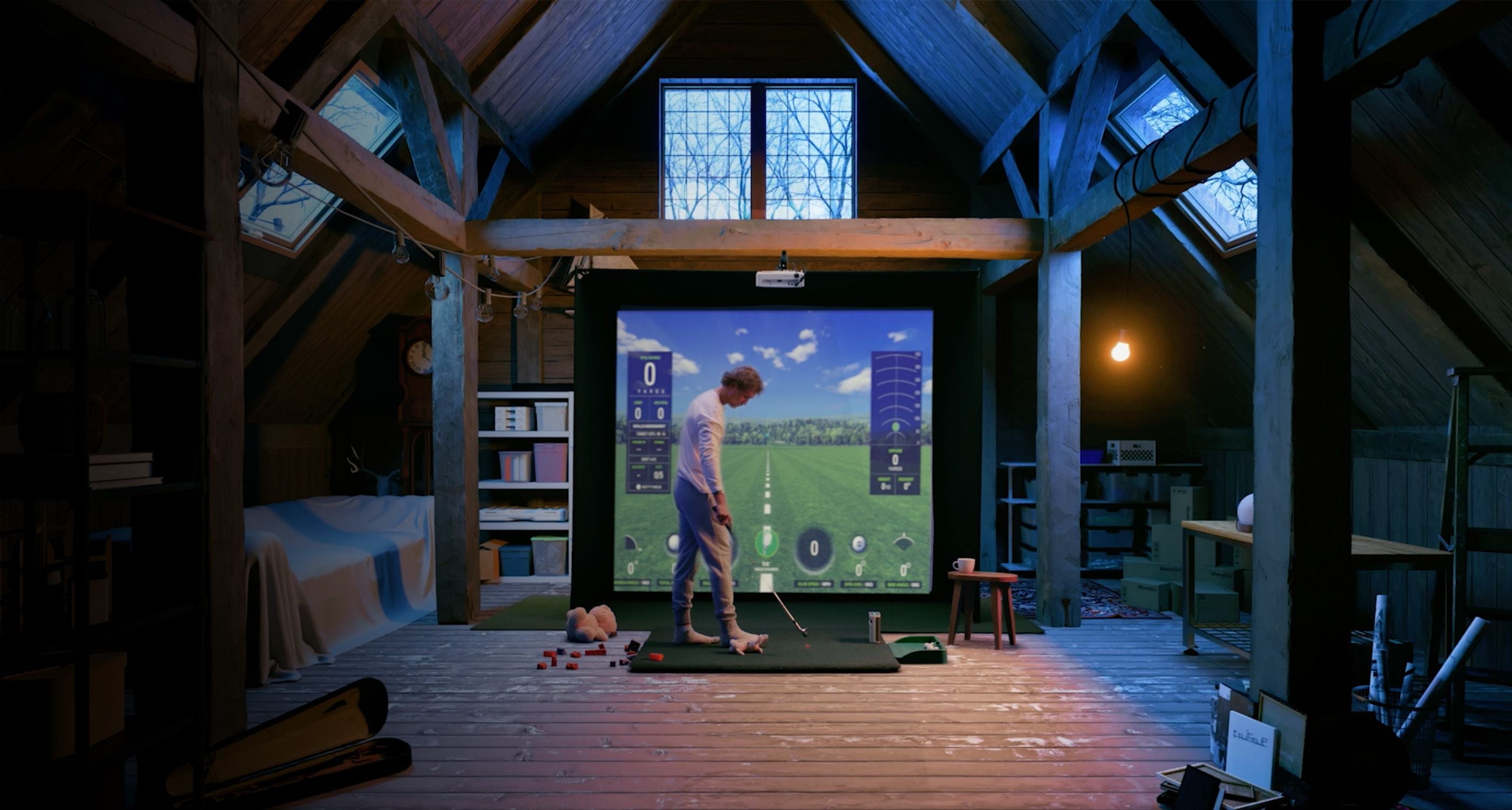 Man in attic playing on SKYTRAK plus golf simulator