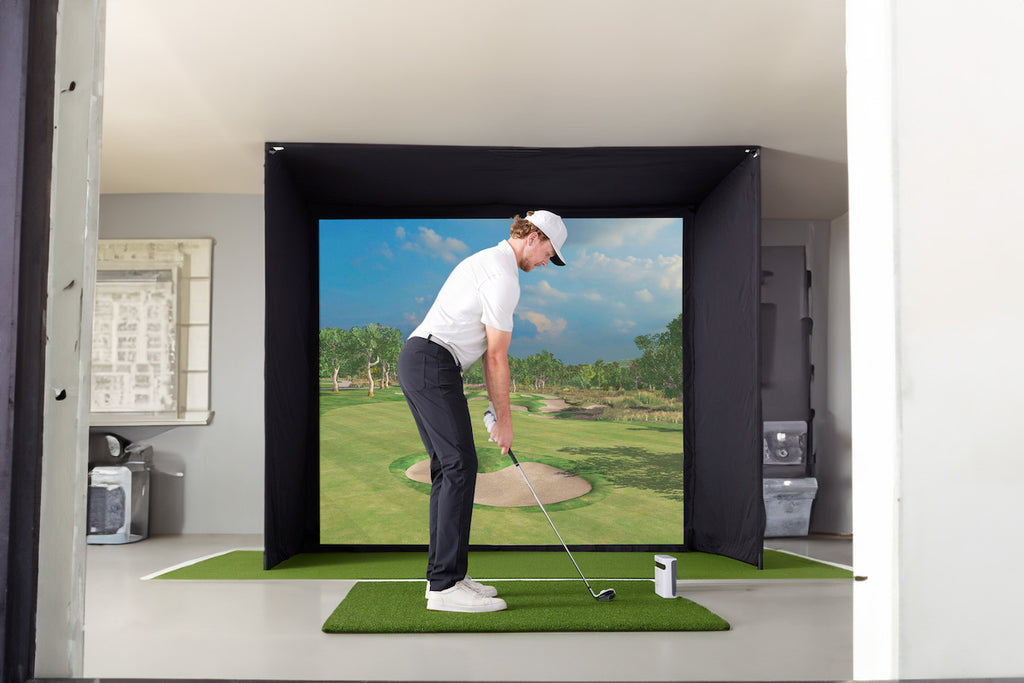 Man in his garage playing simulator golf on the SkyTrak sim studio starter pack