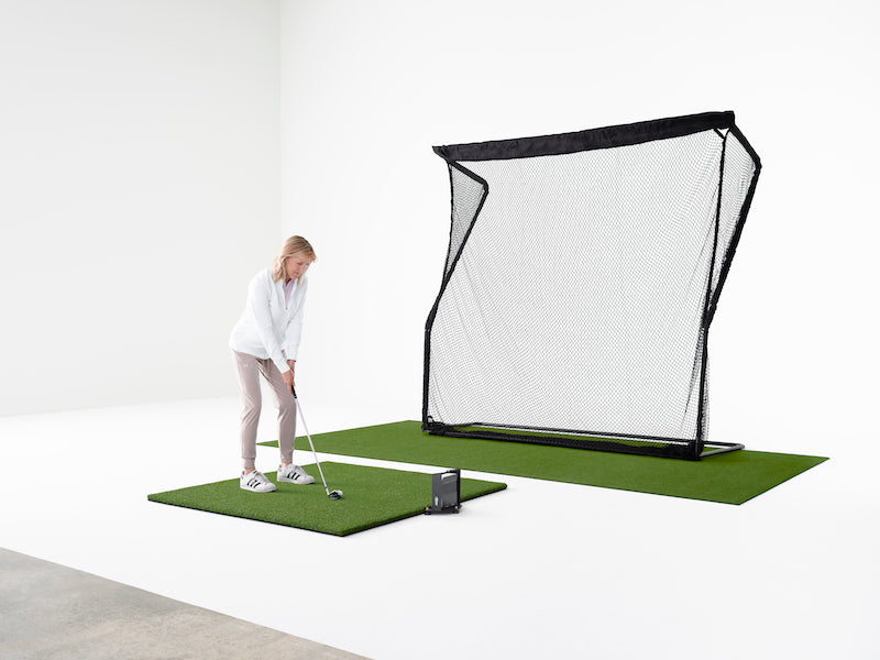 Woman playing on the SkyTrak Golf Simulator Studio practice package