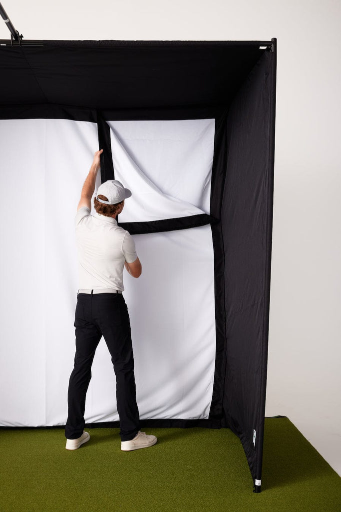 Man putting up high impact screen for SkyTrak Studio enclosure