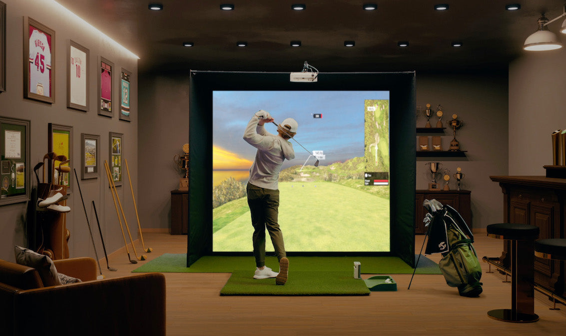 Man Playing golf in his man cave on his SKYTRAK plus golf simulator studio