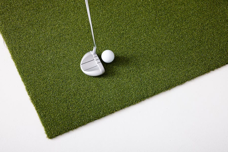 Close up of SkyTrak putting turf with ball and putter.