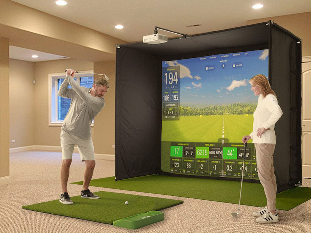 Two people using a golf simulator in a home setting.