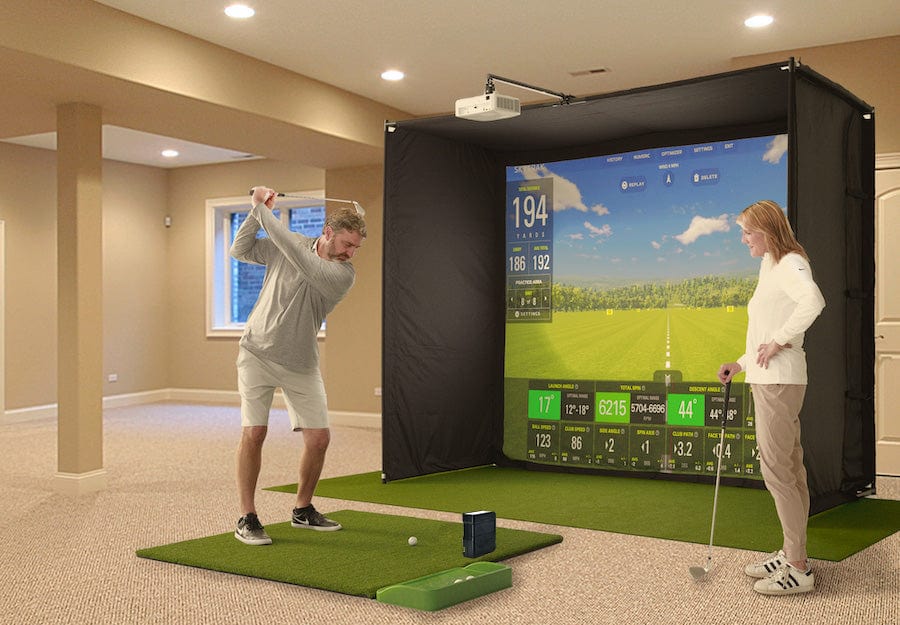 Couple playing golf on the SkyTrak Golf Simulator Studio with the SkyTrak launch monitor