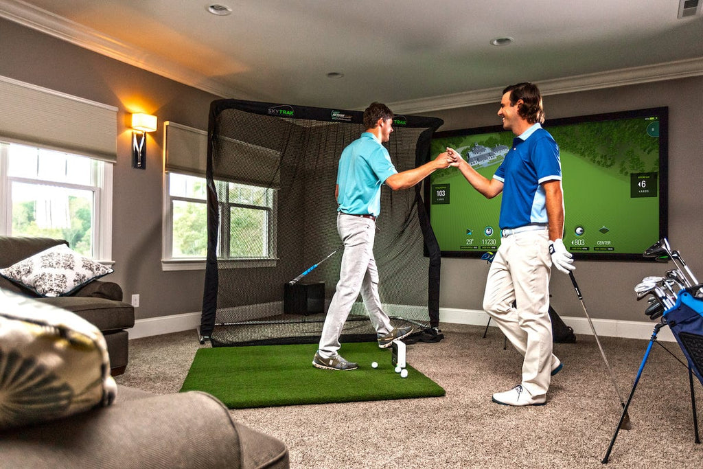 Two guys playing golf in their living room on the SkyTrak launch monitor