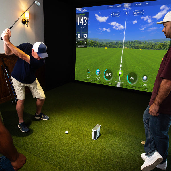 Friends playing simulator golf inside on the SKYTRAK+ launch monitor